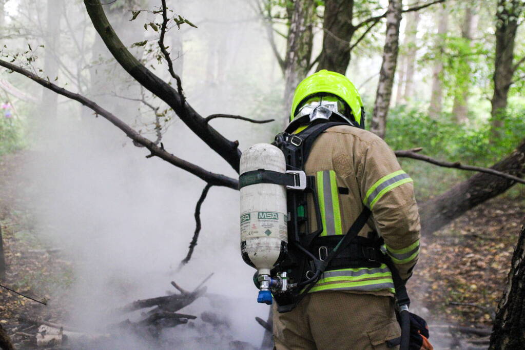 Brandweer blust kampvuur in bos