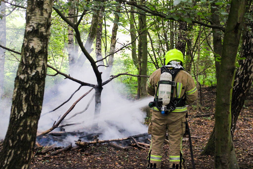 Brandweer blust kampvuur in bos