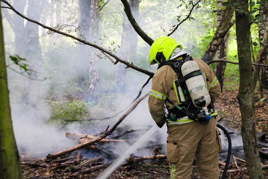 Brandweer blust kampvuur in bos