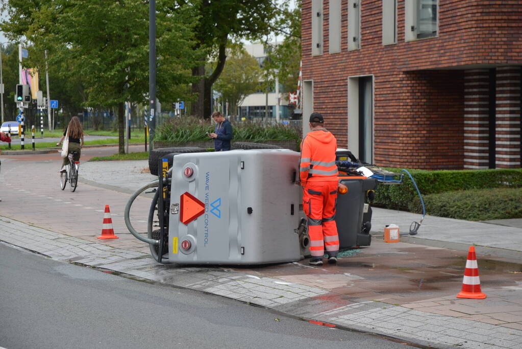 Voertuig van onkruidverdelger kantelt op fietspad