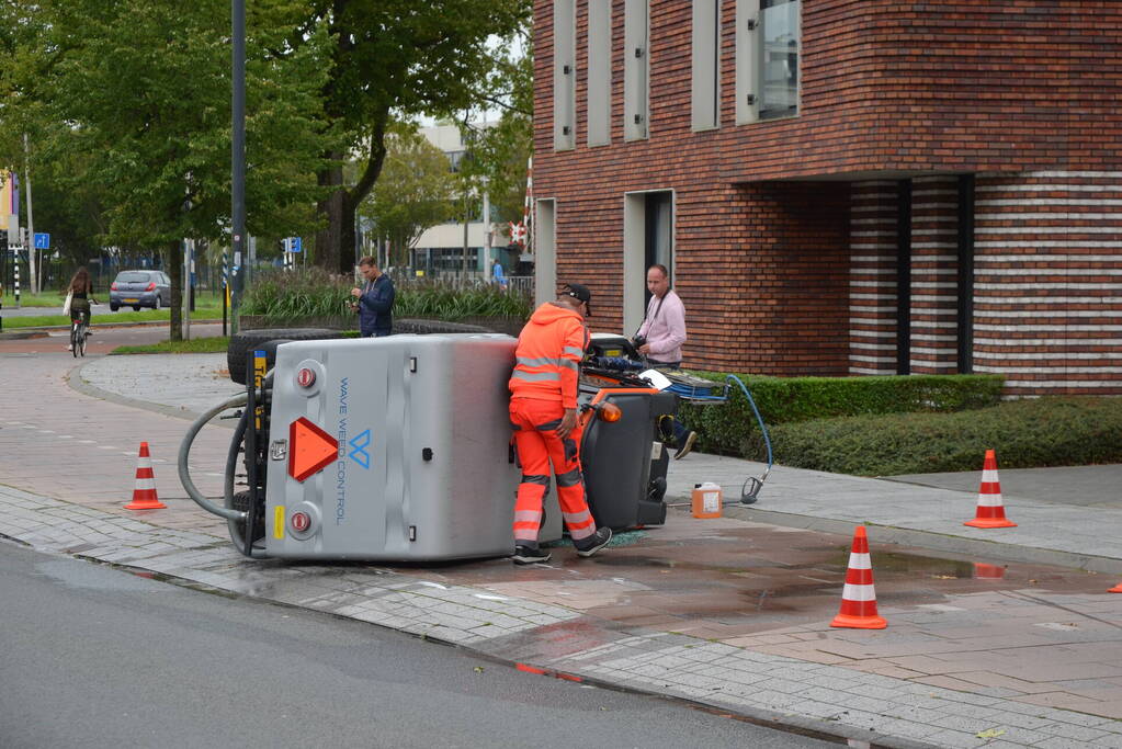 Voertuig van onkruidverdelger kantelt op fietspad