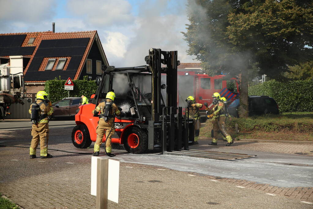 Brandweer blust brandende heftruck