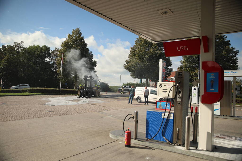 Brandweer blust brandende heftruck