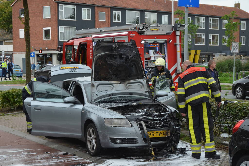 Brandweer blust brand in motorcompartiment van auto