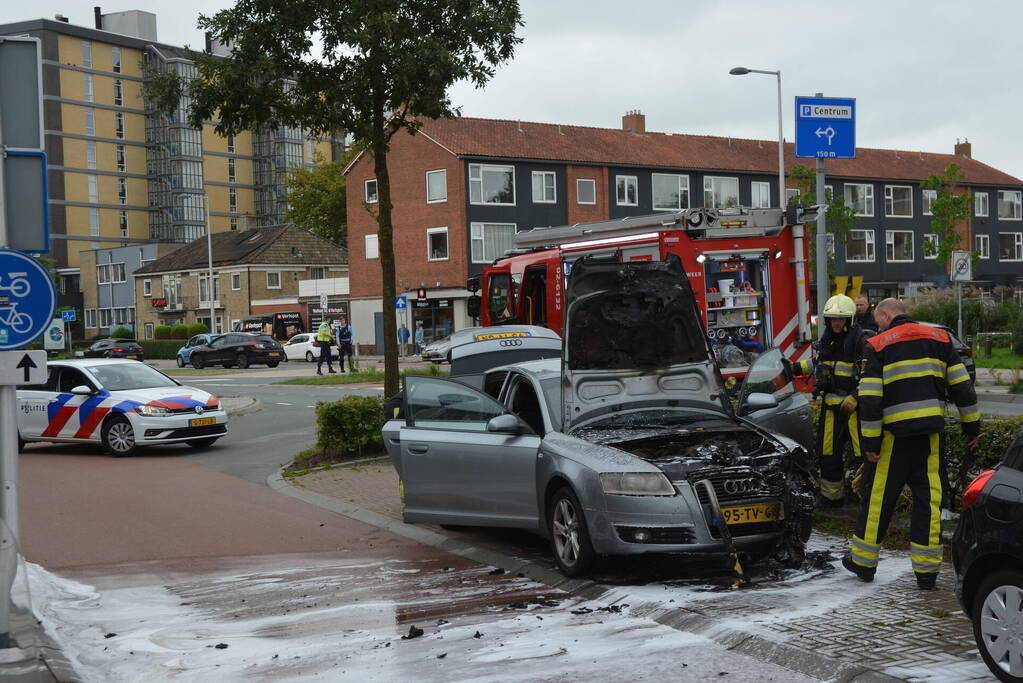 Brandweer blust brand in motorcompartiment van auto