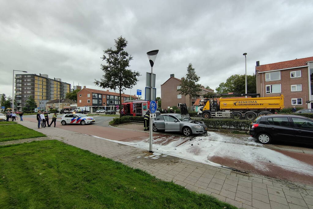 Brandweer blust brand in motorcompartiment van auto