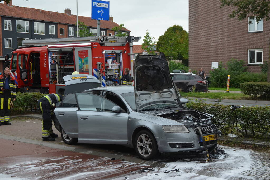 Brandweer blust brand in motorcompartiment van auto