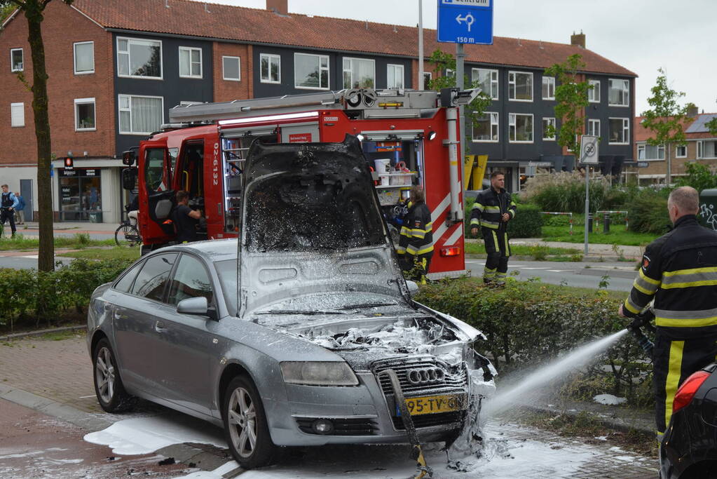 Brandweer blust brand in motorcompartiment van auto