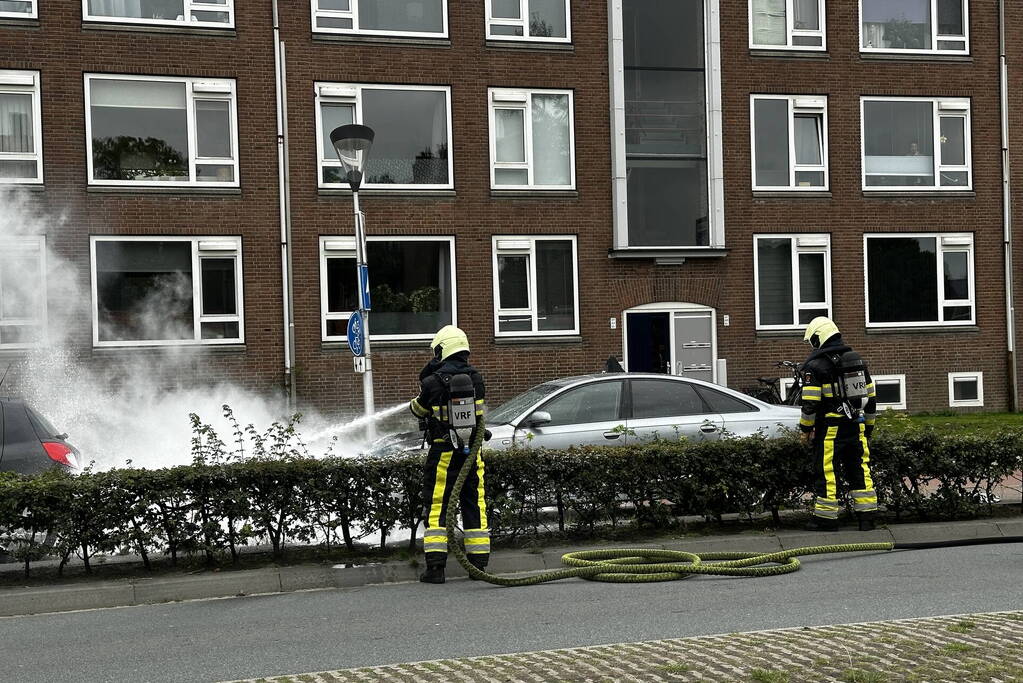 Brandweer blust brand in motorcompartiment van auto