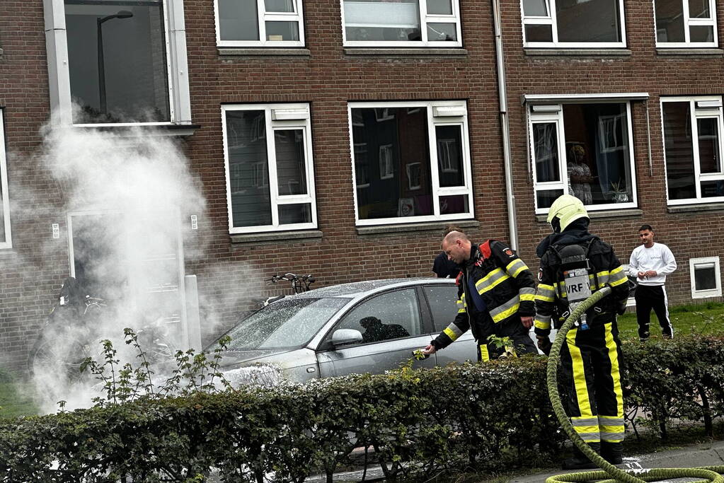 Brandweer blust brand in motorcompartiment van auto