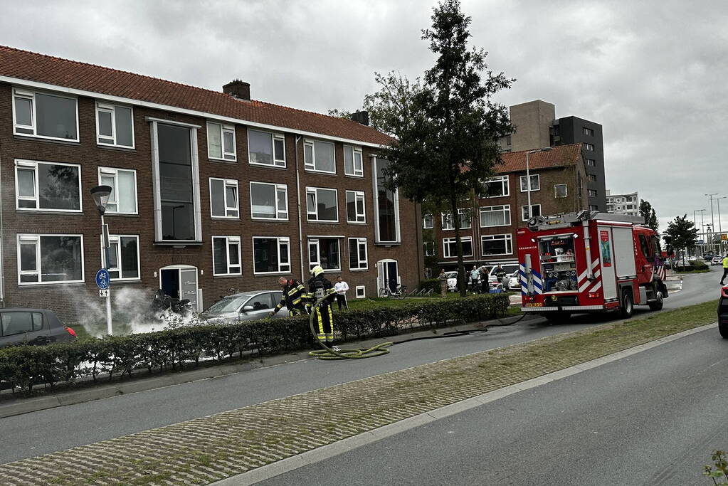 Brandweer blust brand in motorcompartiment van auto