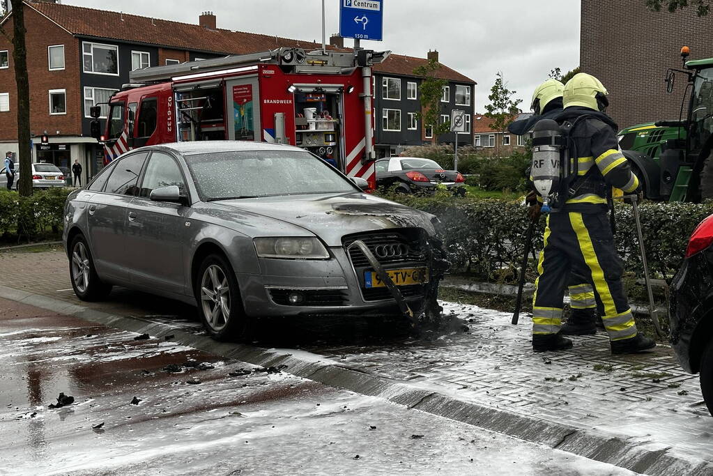 Brandweer blust brand in motorcompartiment van auto