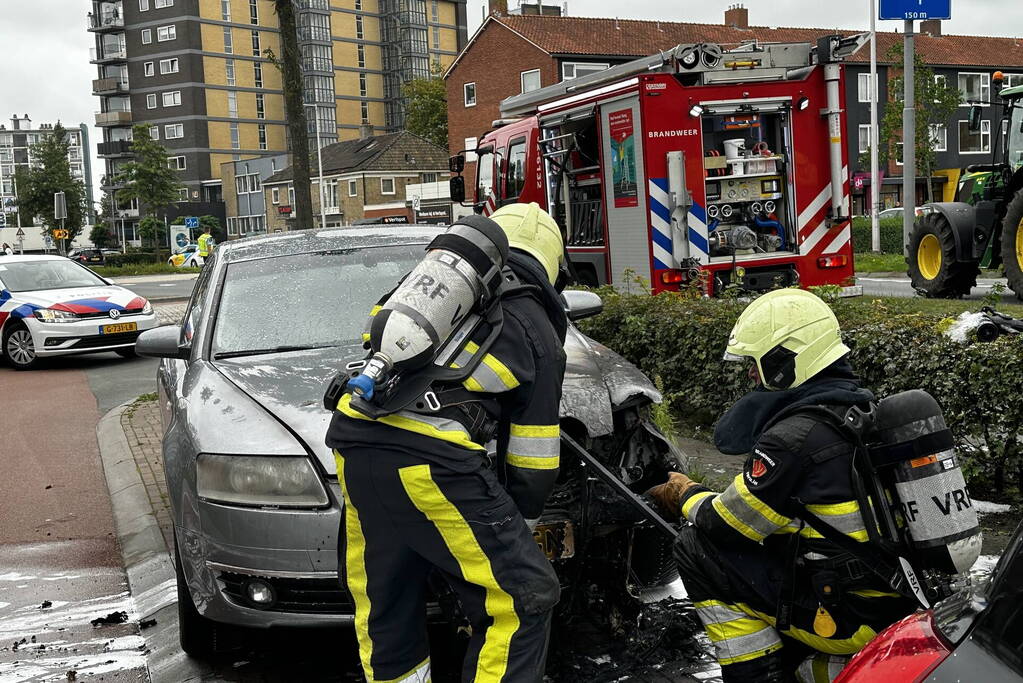 Brandweer blust brand in motorcompartiment van auto