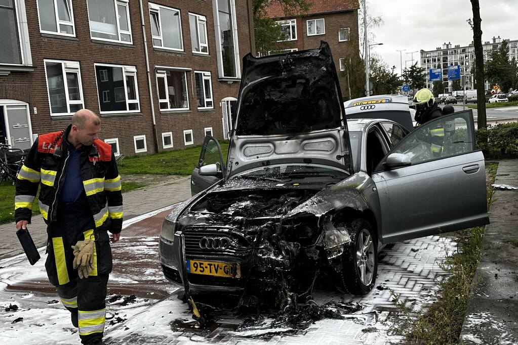 Brandweer blust brand in motorcompartiment van auto