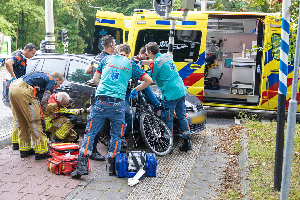 Fietser bekneld tussen auto en paal