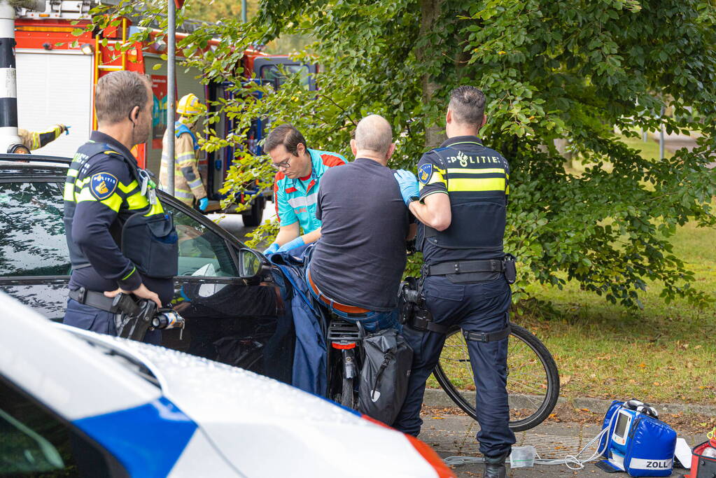 Fietser bekneld tussen auto en paal