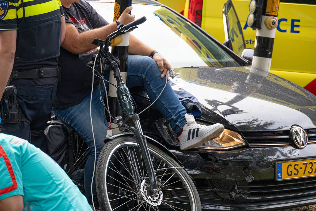 Fietser bekneld tussen auto en paal