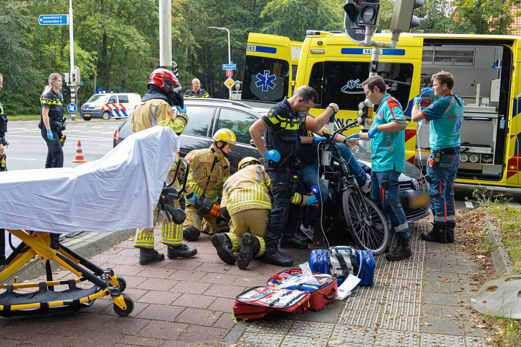 Fietser bekneld tussen auto en paal