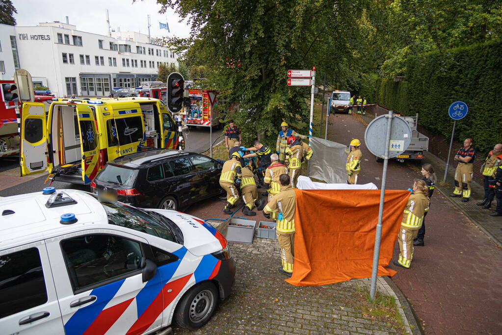 Fietser bekneld tussen auto en paal