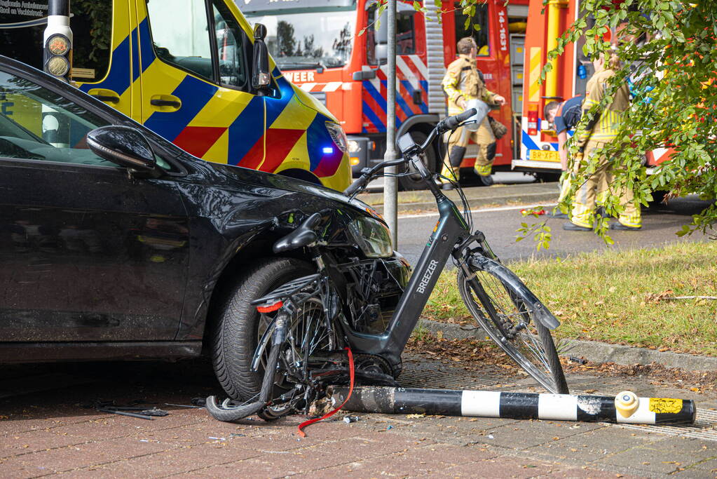 Fietser bekneld tussen auto en paal