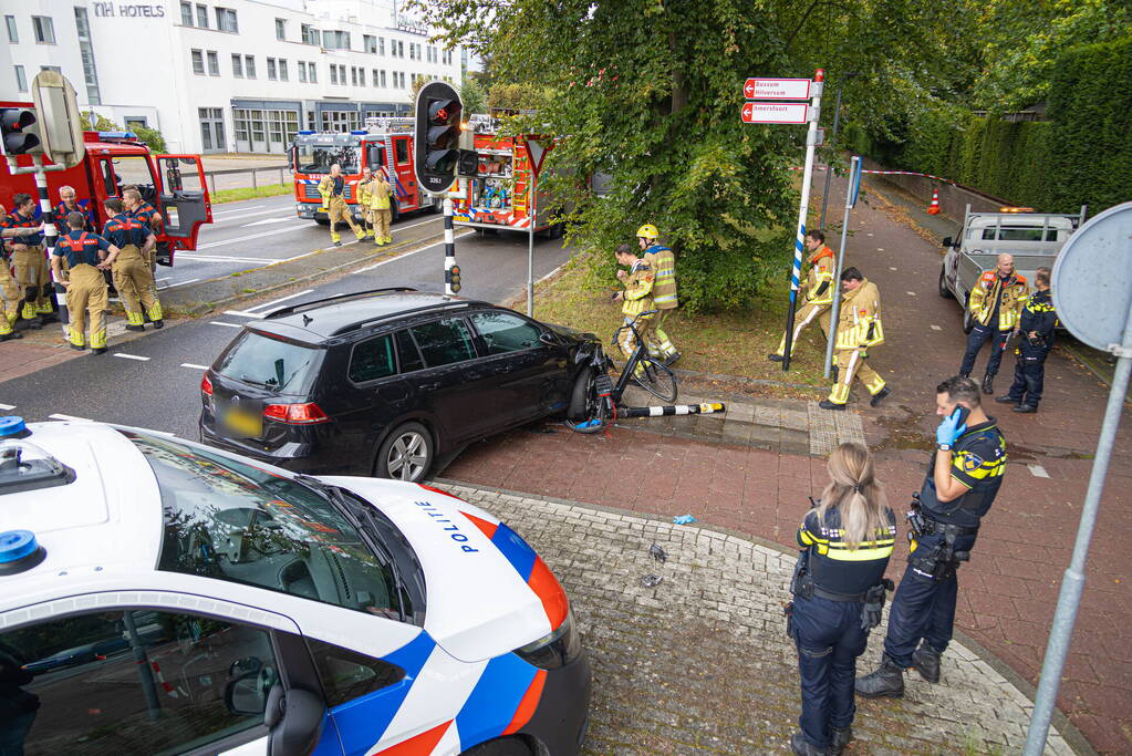 Fietser bekneld tussen auto en paal