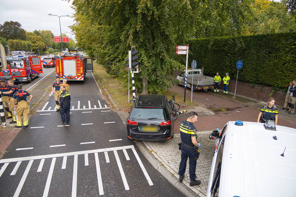 Fietser bekneld tussen auto en paal