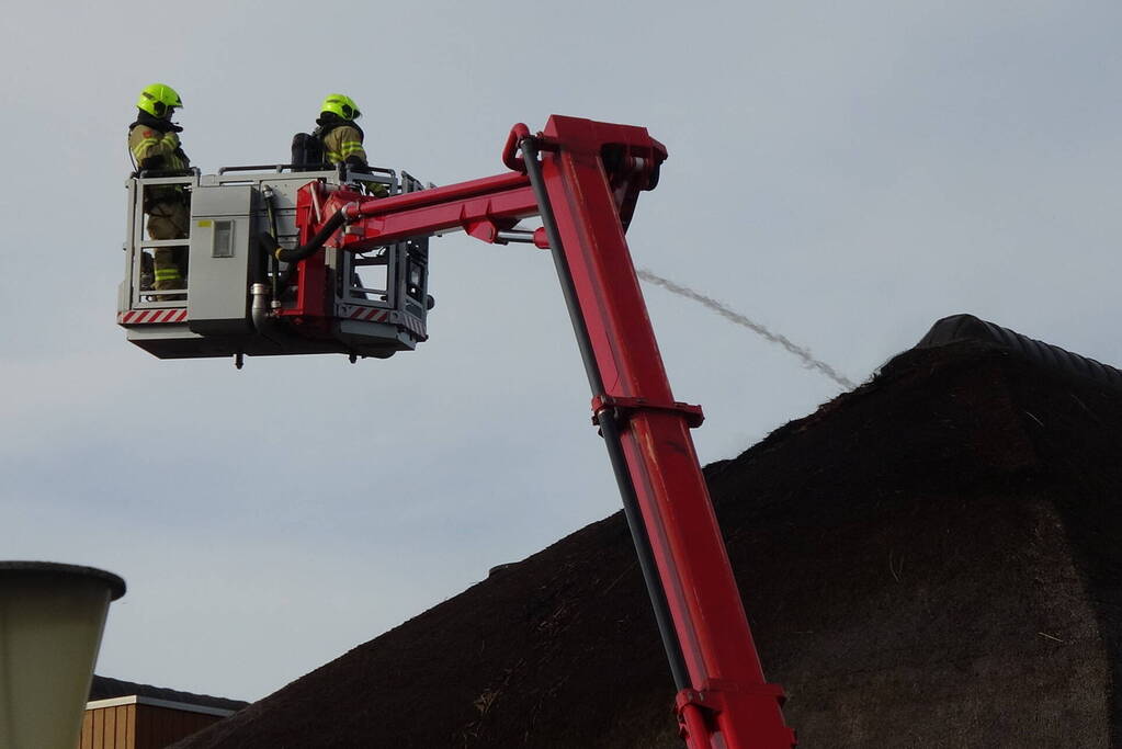 Brand op dak van appartementencomplex met rietendak