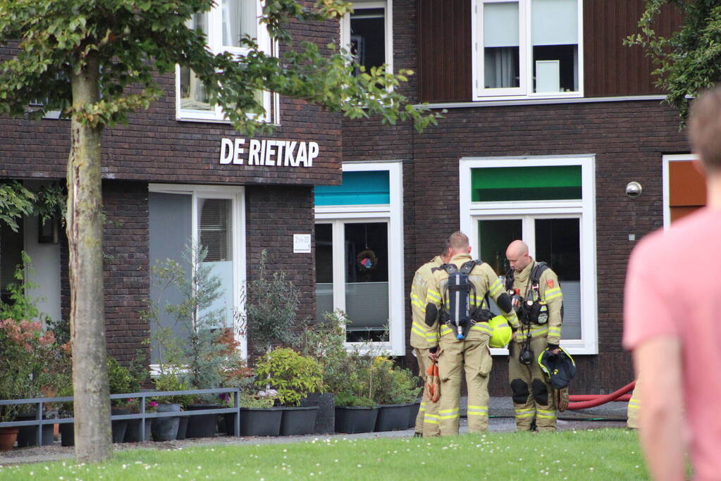 Brand op dak van appartementencomplex met rietendak