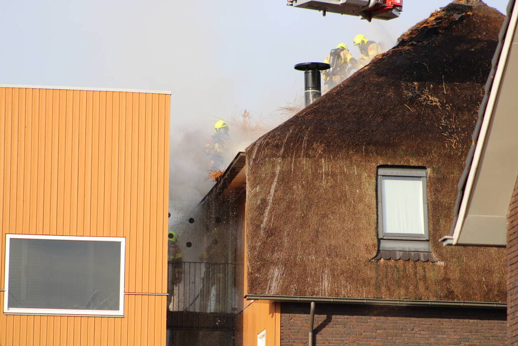 Brand op dak van appartementencomplex met rietendak