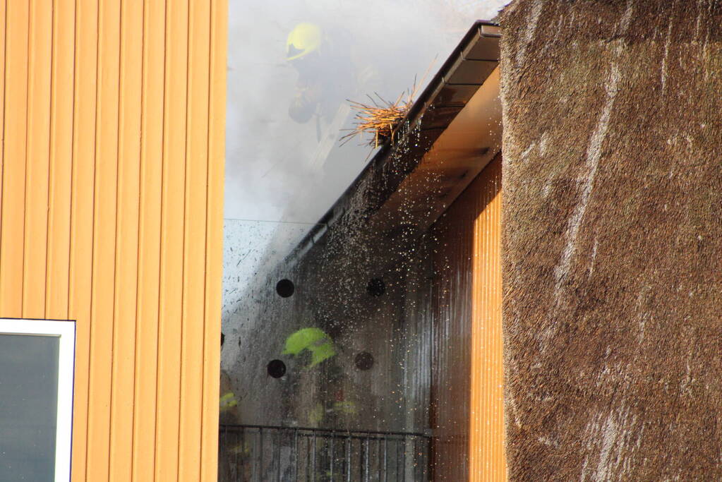 Brand op dak van appartementencomplex met rietendak