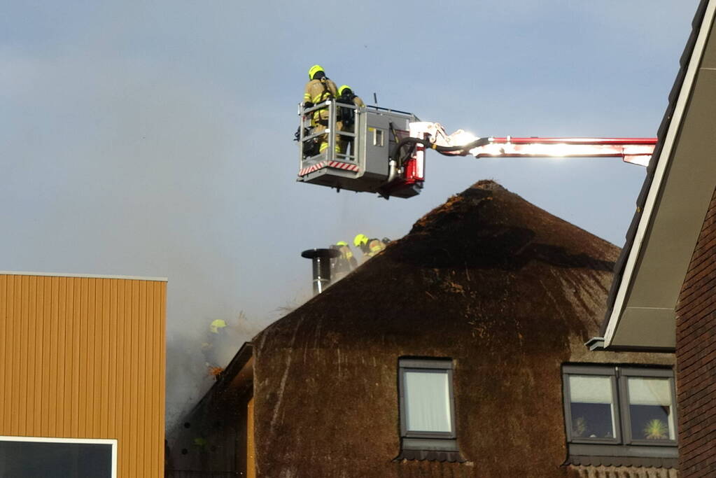 Brand op dak van appartementencomplex met rietendak