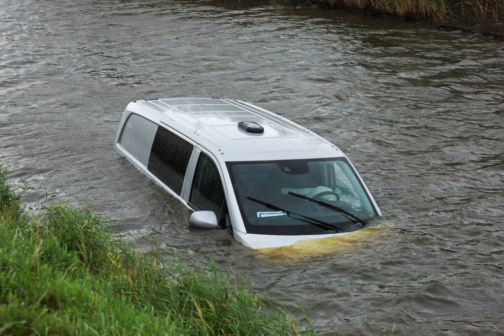 Bestelbus wijkt uit voor dier en rijdt water in