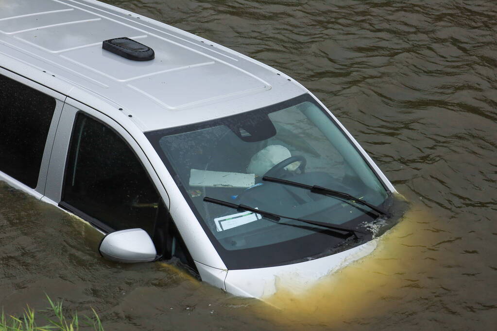 Bestelbus wijkt uit voor dier en rijdt water in