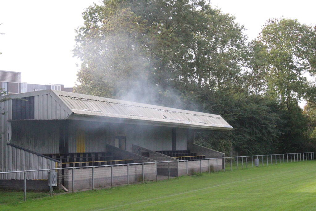 Brandweer blust brand onder voetbaltribune