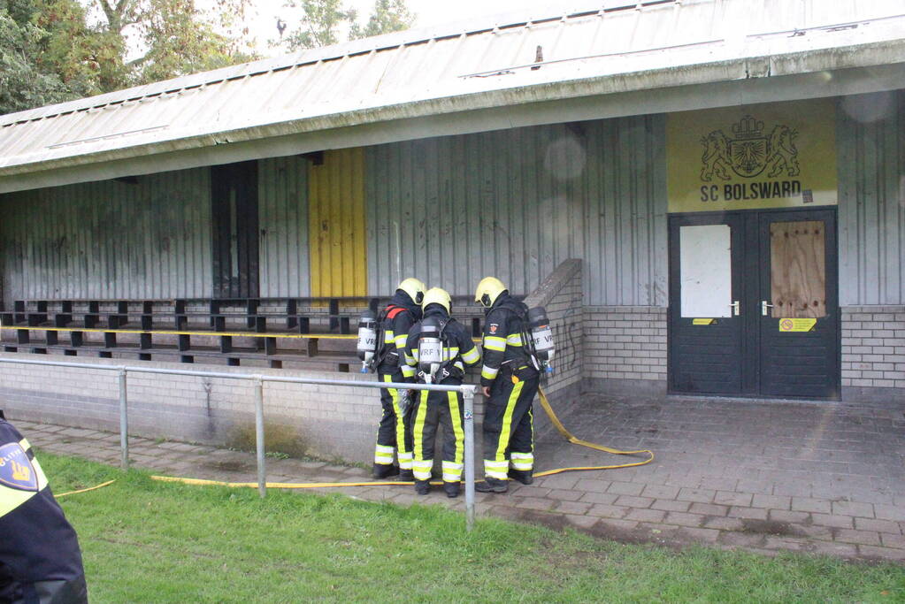 Brandweer blust brand onder voetbaltribune