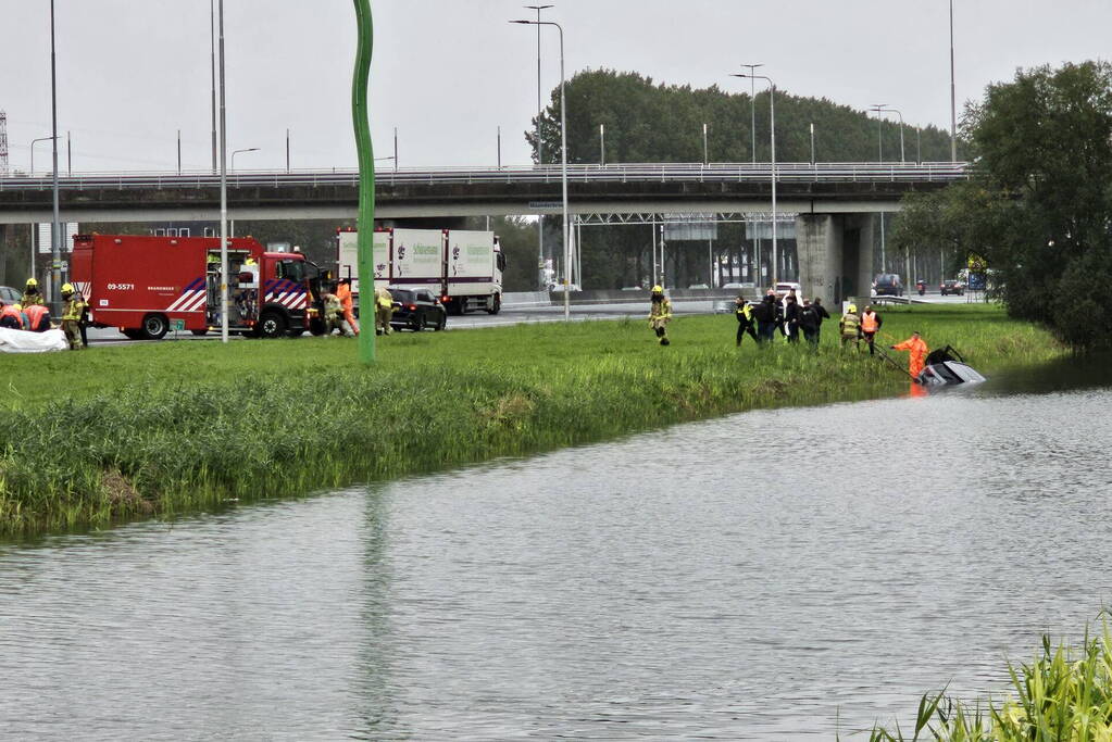 Auto raakt te water naast snelweg