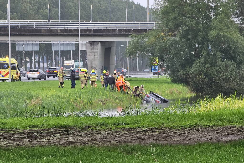 Auto raakt te water naast snelweg