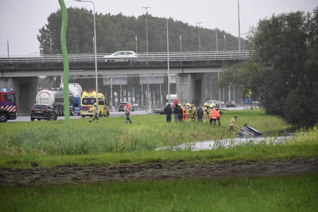 Auto raakt te water naast snelweg