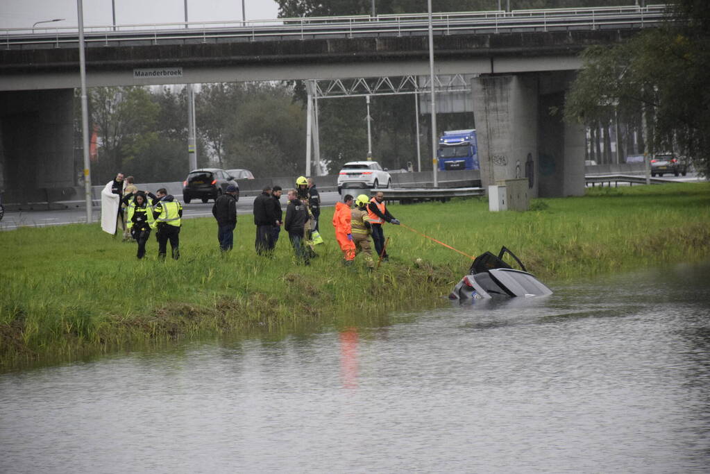 Auto raakt te water naast snelweg