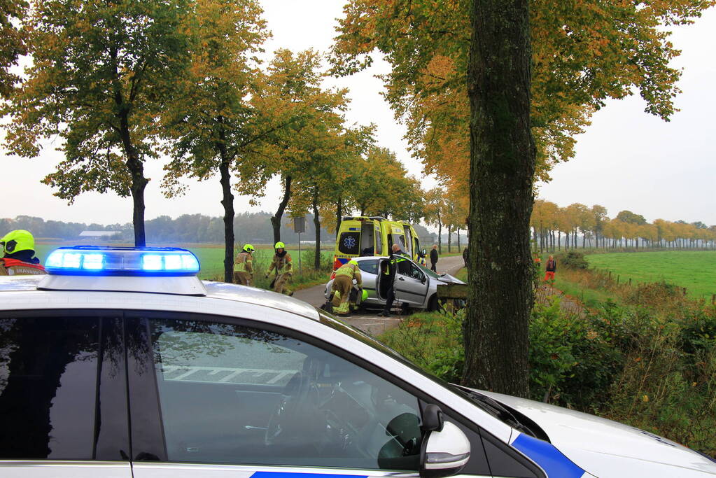 Bestuurder bekneld bij botsing tegen boom