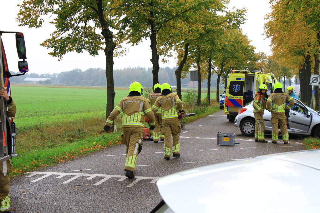 Bestuurder bekneld bij botsing tegen boom