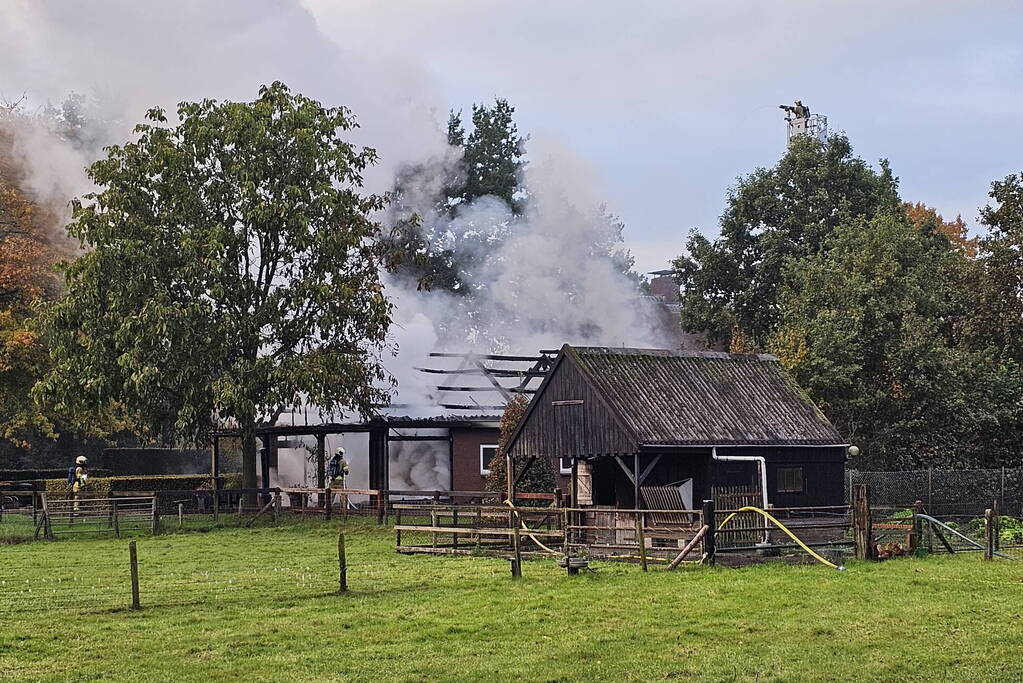 Grote brand in loods dreigt over te slaan naar woning