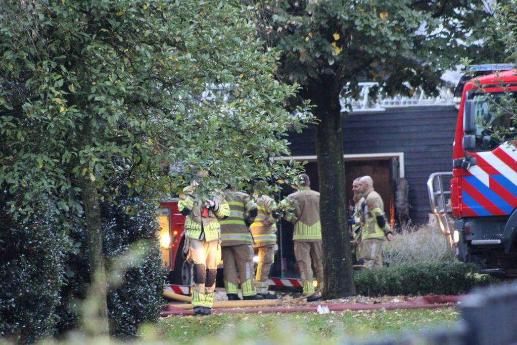 Grote brand in loods dreigt over te slaan naar woning