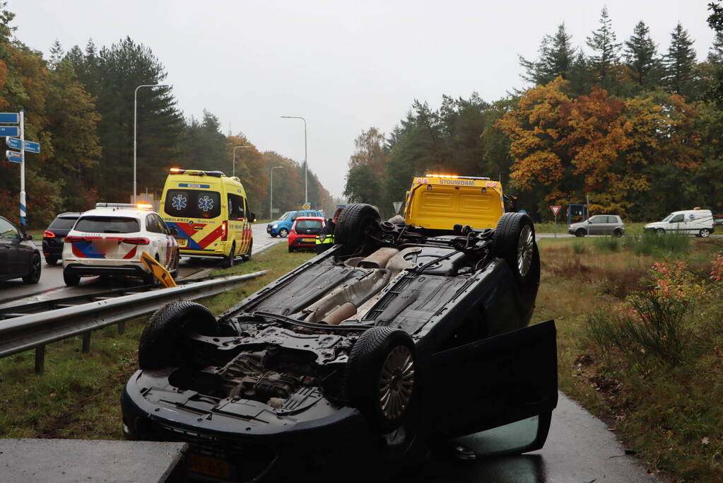 Auto vliegt over vangrail en belandt op kop