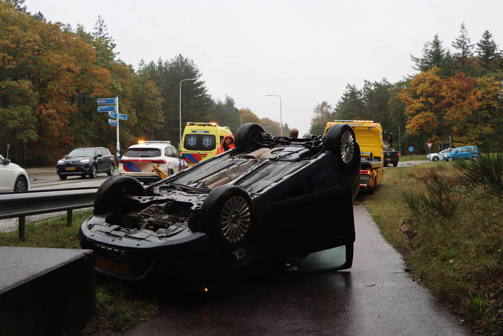 Auto vliegt over vangrail en belandt op kop