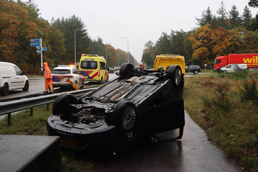 Auto vliegt over vangrail en belandt op kop