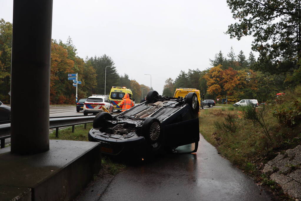 Auto vliegt over vangrail en belandt op kop