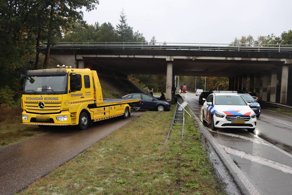 Auto vliegt over vangrail en belandt op kop