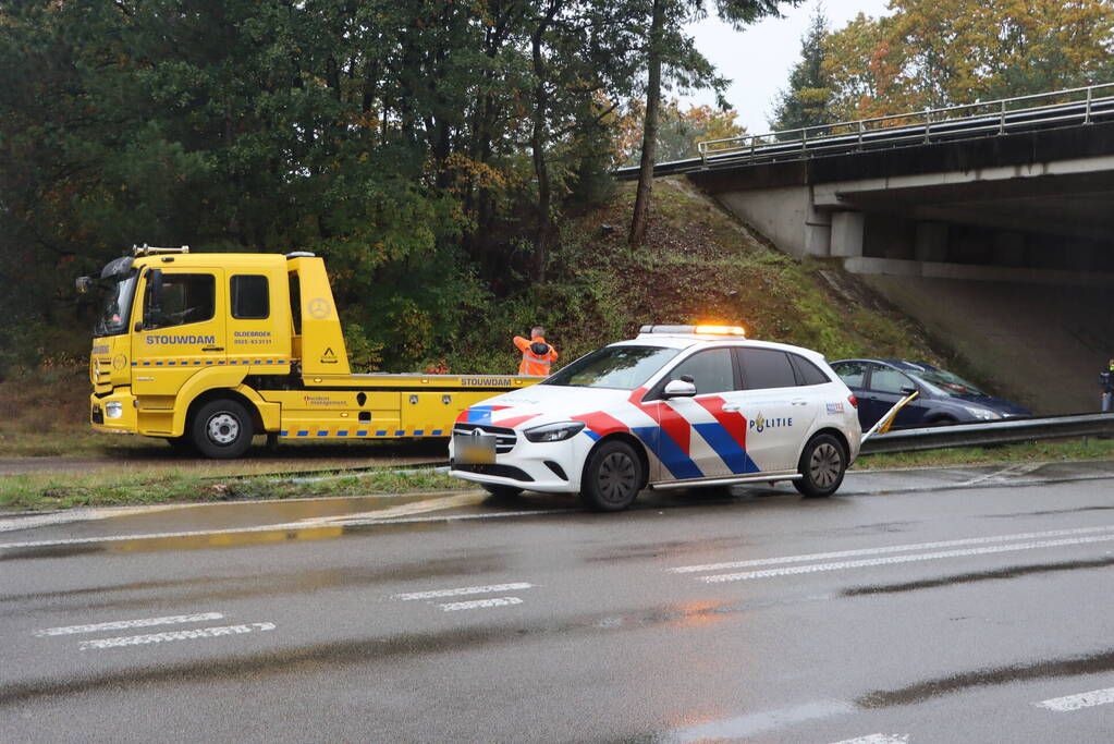 Auto vliegt over vangrail en belandt op kop