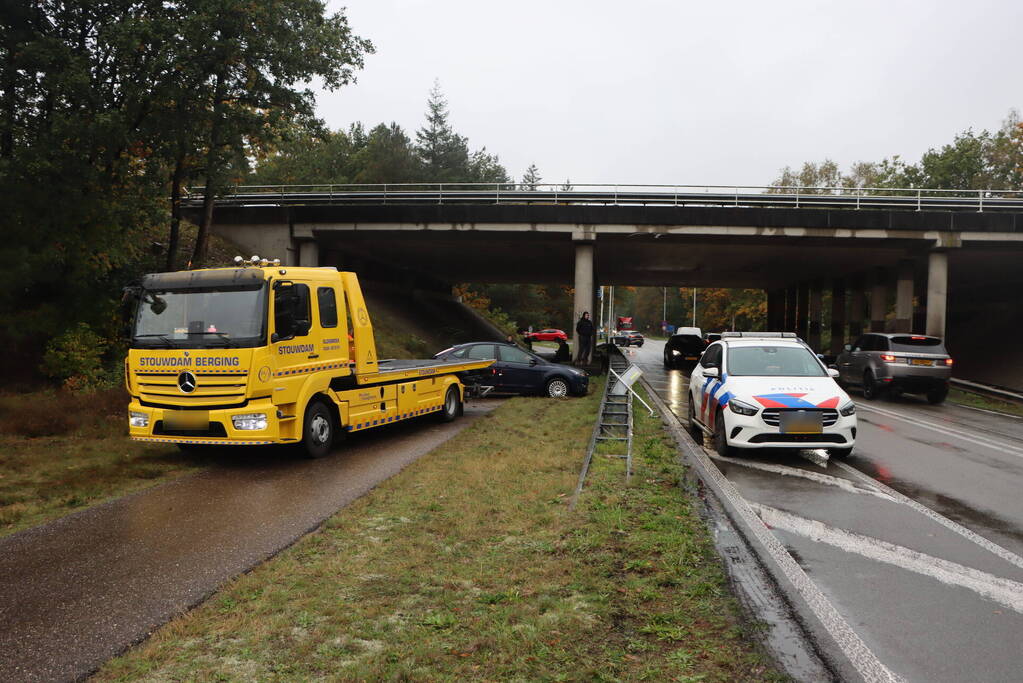 Auto vliegt over vangrail en belandt op kop